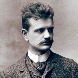 The composer Jean Sibelius as a young man, in a suit, vest, and high color, sporting a mustasche