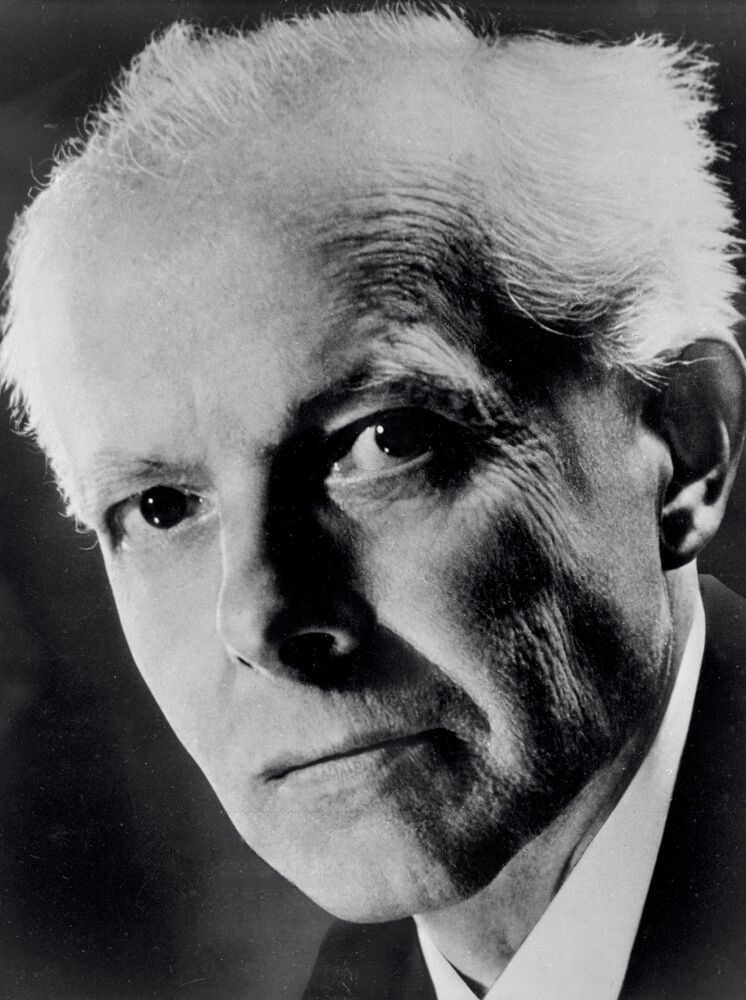 Black and white portrait of a mature man with white hair, serious expression, and penetrating gaze.